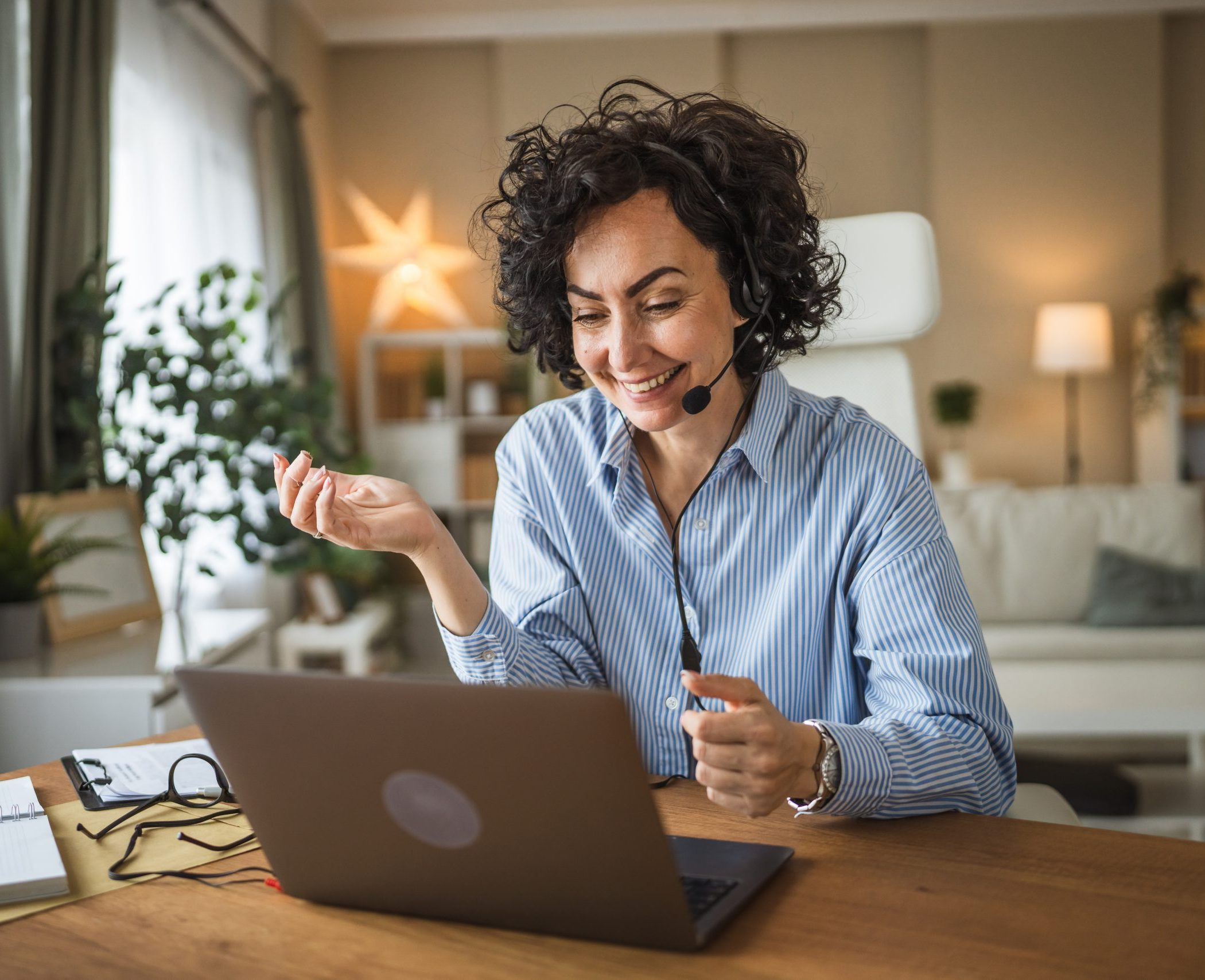 call center female agent wearing headset talk to client at home office